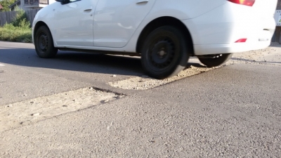 Stradă şi trotuare distruse, autorităţile se fac că nu văd