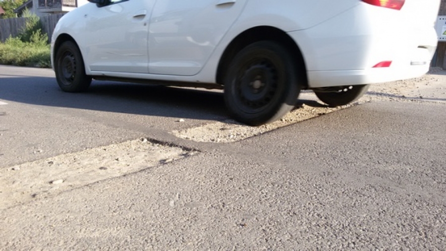 Stradă şi trotuare distruse, autorităţile se fac că nu văd