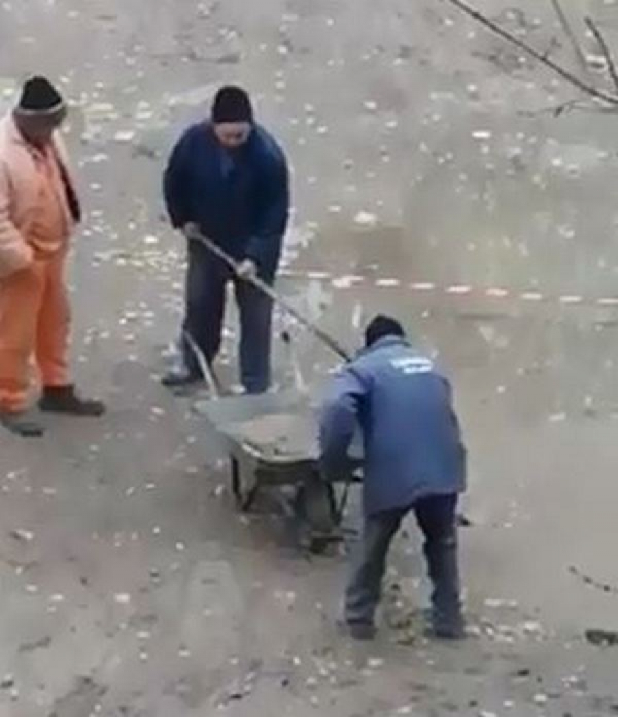 VIDEO: Muncitori filmaţi în timp ce cărau cu roaba apa de ploaie dintr-o groapă