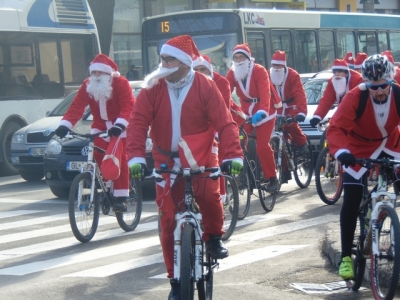 Mai mulţi Moş Crăciun, la colindat prin oraş, pe bicicletă