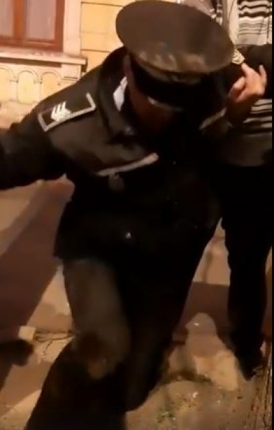 Poliţist local în uniformă rupt de beat, filmat pe stradă de trecători
