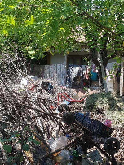 Îngropaţi în mizerie, de bunăvoie: O familie din Independenţa şi-a transformat curtea casei în groapă de gunoi