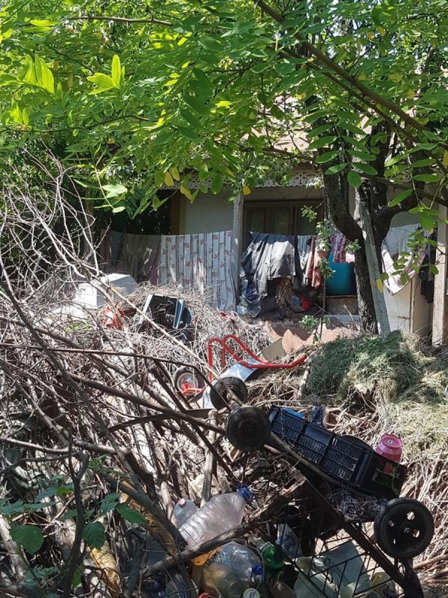 Îngropaţi în mizerie, de bunăvoie: O familie din Independenţa şi-a transformat curtea casei în groapă de gunoi