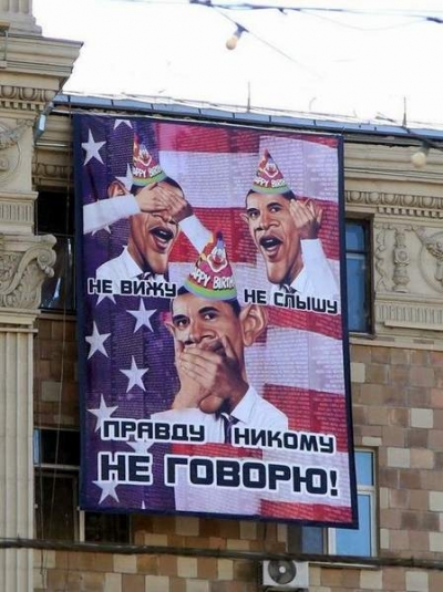 Obama, comparat cu cele "Trei maimuţe înţelepte", într-un banner afişat pe o clădire din Moscova