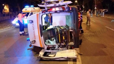 Ambulanţă răsturnată, trei răniţi şi fugă de la locul faptei
